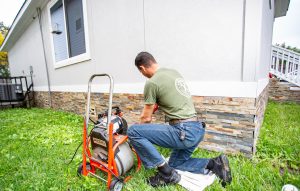 H-Town Plumbers plumber operating a sewer drain cleaning machine in a backyard