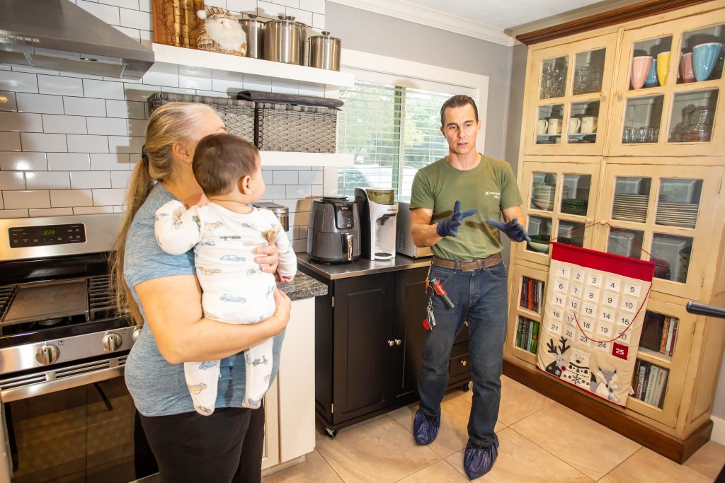 H-Town Plumbers plumber talking with a homeowner in a kitchen